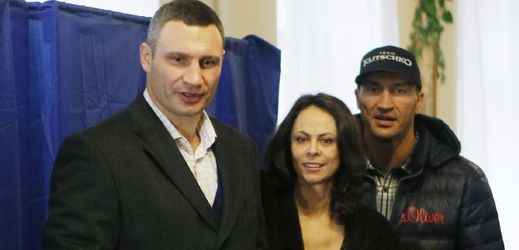 Vitalij Kličko (vlevo) na dnešních volbách za podpory své ženy a bratra Vladimíra.