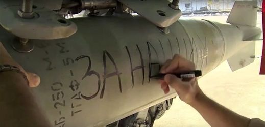 Ruský technik píše vzkaz na bombu určenou ke svržení na Islámský stát. 