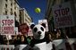 Demonstrant oblečený jako medvídek panda pochoduje v ulicích v centru Madridu s ostatními lidmi, kteří drží transparenty s nápisy Zastavte klimatické změny. Španělsko.