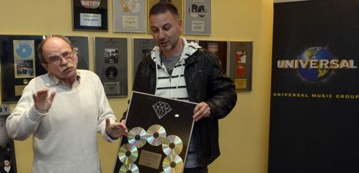 Jaroslav Uhlíř (vlevo) převzal 7. prosince v Praze z rukou Marcela Vyšína z vydavatelství Universal Music diamantovou desku za prodej půl milionu alb autorských písniček pro malé i velké posluchače.