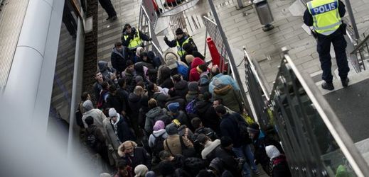 Policie organizuje uprchlíky přijíždějící z Dánska na vlakové nádraží Hyllie ve Švédsku.