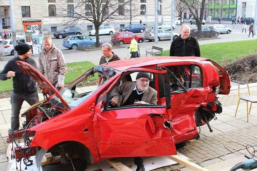 Vrakem auta vyzdobili organizátoři výstavy prostor v Domě umění města Brno, kde se uskuteční výstava fotografií Václava Jiráska (na snímku uprostřed), který se ve své tvorbě věnuje právě automobilovým vrakům.