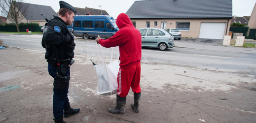 Uprchlík kontrolován policistou (ilustrační foto).