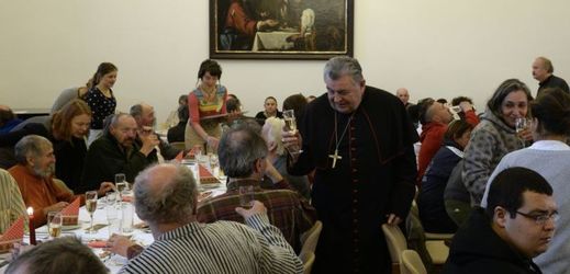 Kardinál Dominik Duka (uprostřed) zahájil 25. prosince v Praze vánoční oběd pro lidi bez domova, seniory, uprchlíky a handicapované.