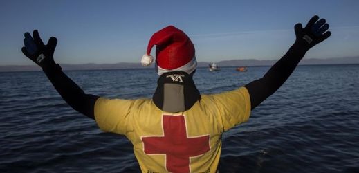 Člen Červeného kříže vítá uprchlíky na řeckém ostrově Lesbos (ilustrační foto).