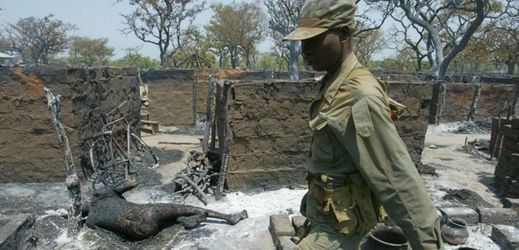 Vládní voják prochází zničeným uprchlickým táborem Barlonyo v severní Ugandě, jehož obyvatele zmasakrovali ozbrojenci z povstalecké Armády božího odporu (ilustrační foto).