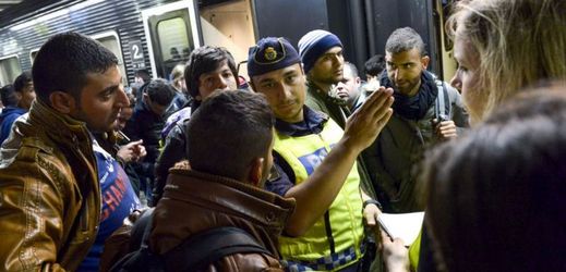 Uprchlíci dostávají na nádraží pokyny od švédského policisty.