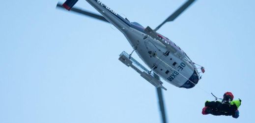 Vrtulník záchranářů přepravuje zraněné lyžaře z české výpravy do nemocnice.