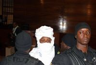Hissene Habré obestoupený soudní ochrankou.