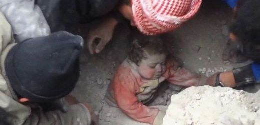 Vyprošťování děvčátka ze sutin v bombardovaném syrském městě Aleppo.