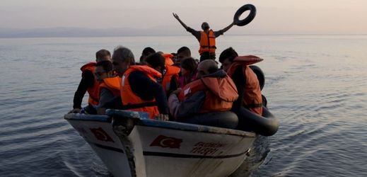 Uprchlí vzdávající dík bohu za úspěšné zdolání cesty po Egejském moři na rybářském člunu z Turecka na řecký ostrov Lesbos.