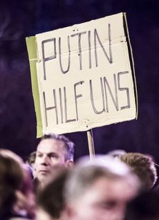 Transparent hlásá: Putine, pomoz nám. Demonstrace odpůrců azylové politiky v německém Erfurtu.