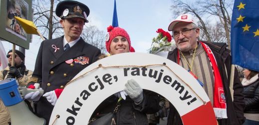 Demonstrující ve Varšavě nesou záchranný kruh s nápisem Zachráníme demokracii.