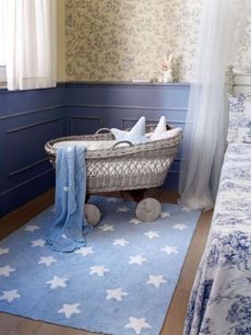 Pokojík pro miminko s kobercem s hvězdami a přehozem s puntíky.