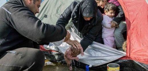 Omývání novorozence v uprchlickém táboře.