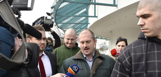 Obklopen novináři. Marian Kotleba odchází z televizní debaty. 6. března, den po volbách.