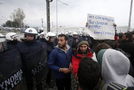 Migranti s transparenty poklidně demontsrují.