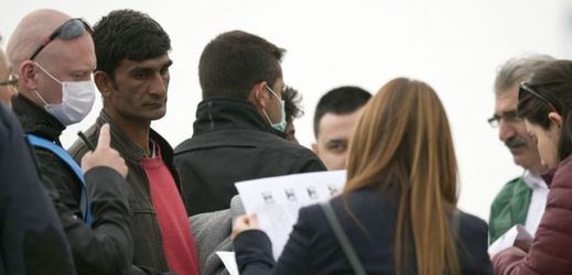 Pracovníci agentury Frontex a zaměstnanci tureckého ministerstva vnitra kontrolují doklady pákistánského migranta (druhý zleva).