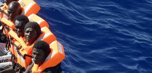 Afričtí migranti plující na člunu ve Středozemním moři u libyjského pobřeží.