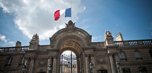 Francouzská vlajka na půl žerdi nad prezidentským palácem Elysee v Paříži.