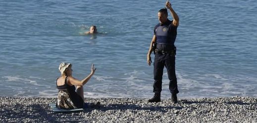 Policista žádá návštěvníky pláže, aby se přesunuli dál od místa masakru.