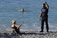 Policista žádá návštěvníky pláže, aby se přesunuli dál od místa masakru.