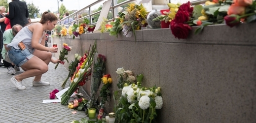 Lidé nosí květiny k provizornímu památníku poblíž místa střelby.