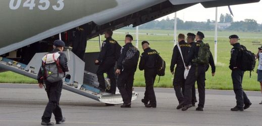 Policisté nastupují do letadla na letišti v pražských Kbelích.