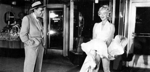 Snímek zachycující fotografování Marilyn Monroe nad pouličním větrákem. Vlevo na snímku autor proslulé fotografie Sam Shaw.