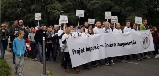 Demonstrace občanů v Forges-les-Bains jižně od Paříže. Transparent hlásá přímou úměrnost mezi plánem nařízeným shora a zvýšeným hněvem.