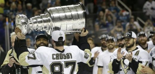 Sidney Crosby zvedá nad hlavu Stanley Cup.
