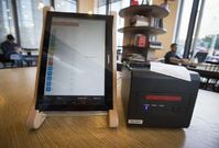 Tablet a tiskárna účtenek v kavárně.