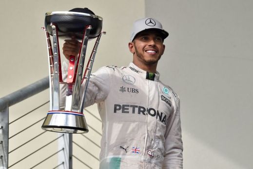 Lewis Hamilton s trofejí pro šampióna.
