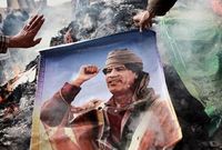 Lidé pálící podobiznu libyjského diktátora Muammara Kaddáfího.