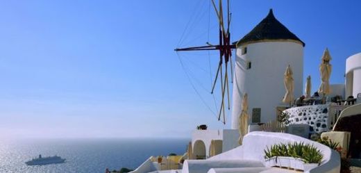 Na fotografii luxusní hotely a větrný mlýn v řecké vesnici Oia, Kyklady.