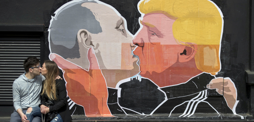 Mladý pár se líbá před graffiti karikaturou Trumpa s Putinem, Vilnius.