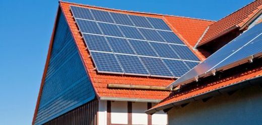 Lidé si montují malé solární panely na střechy rodinných domů.