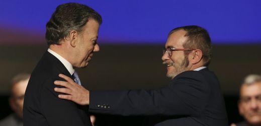 Kolumbijský prezident Juan Manuel Santos (vlevo) a lídr FARC Rodrigo Londoňo, známý také jako Timoleón Jiménez či Timošenko (vlevo) a právě podepsali mírovou dohodu.