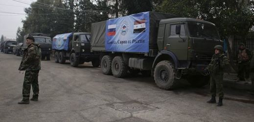 Ruští a syrští vojáci v Aleppu stojí vedle konvoje s pomocí.