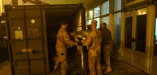 Vojáci vykládají materiál z kontejneru a připravují ho k odbavení pro let.
