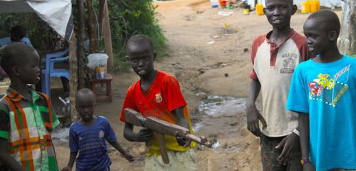 Skupinka dětí se s provizorní pistolí připravuje na nábor do dětské armády v Jižním Súdánu.