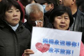 Příbuzní cestujících, kteří byli na palubě zmizelého letadla Malaysia Airlines, se shromáždili před chrámem lam Yonghegong v Pekingu.