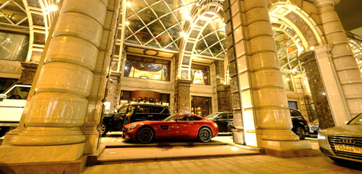 Luxusní vozidla stojící u vchodu Moskevského hotelu.