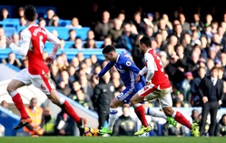 Eden Hazard (v modrém) vstřelil druhý gól Chelsea v utkání. Zde uniká svému soupeři Francisu Coquelinovi z Arsenalu.