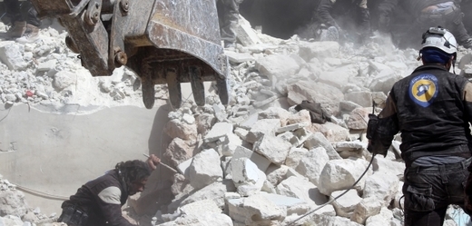 Záchranáři zabezpečují místo po vzdušných náletech v syrském městě Idlib.