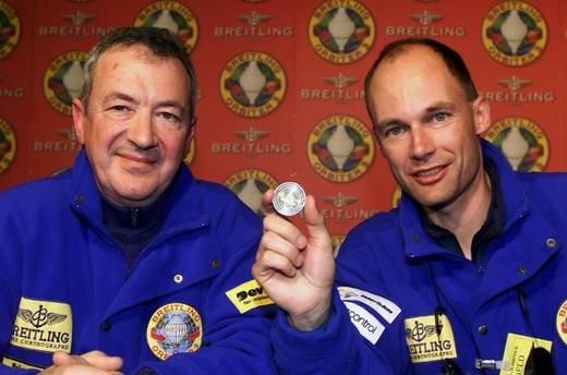 Švýcar Bertrand Piccard (vpravo) a Brit Brian Jones ukazují svou minci pro štěstí před startem k jejich třetímu pokusu o oblet světa bez mezipřistání v horkovzdušném balonu Breitling Orbiter III ze švýcarského Chateau d'Oex.