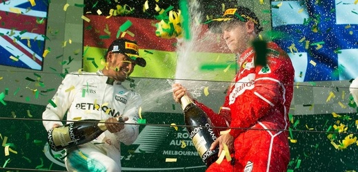 Brit Lewis Hamilton (zleva) kropí šampaňským vítěze VC Austrálie Sebastiana Vettela z Německa.