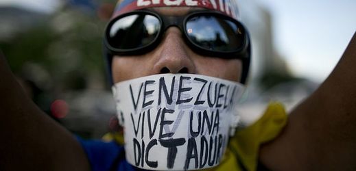 Demonstrující proti vládě ve venezuelském Caracasu. (Na nápisu stojí: "Venezuela žije v diktatuře").