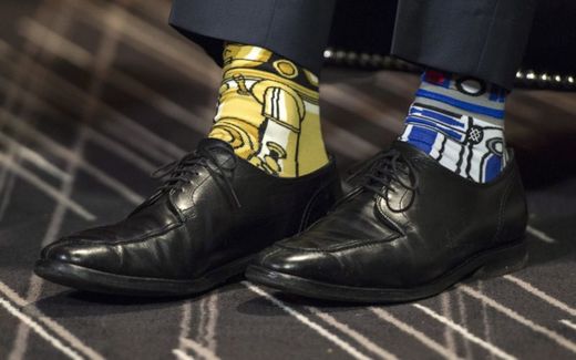 Zářivě žlutá a modrá ponožka s motivem robotů R2-D2 a C-3PO.