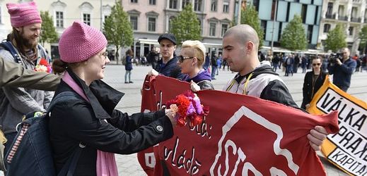 Na snímku se odpůrci krajní pravice snaží předat květinu dvojici pravicových příznivců s transparentem, kteří se sešli 1. května na náměstí Svobody v Brně k prvomájovému pochodu.